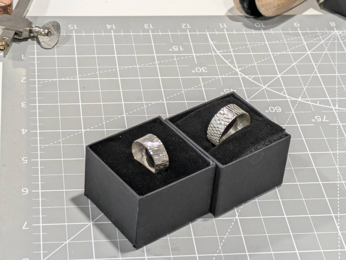 Textured silver rings displayed in boxes